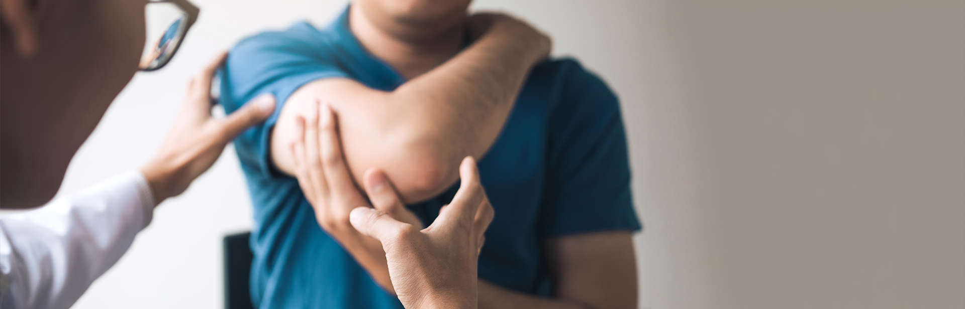 surgeon examining patient's shoulder