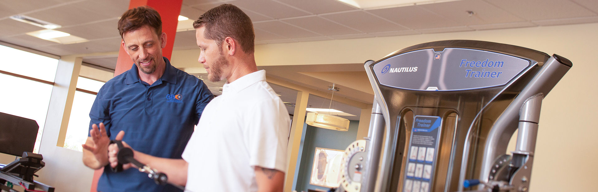 Joel Peck, DPT, helps a patient with shoulder exercises