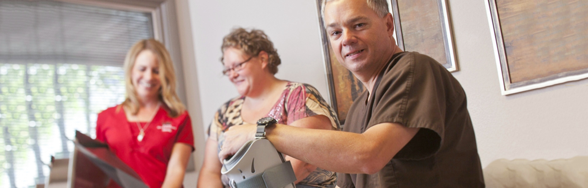 Dr. Richard Hayes holds a foot boot with patient in background