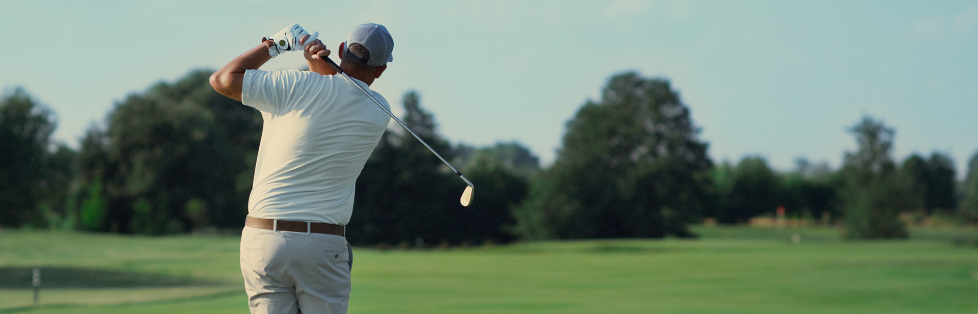 Back of a man swinging a golf club