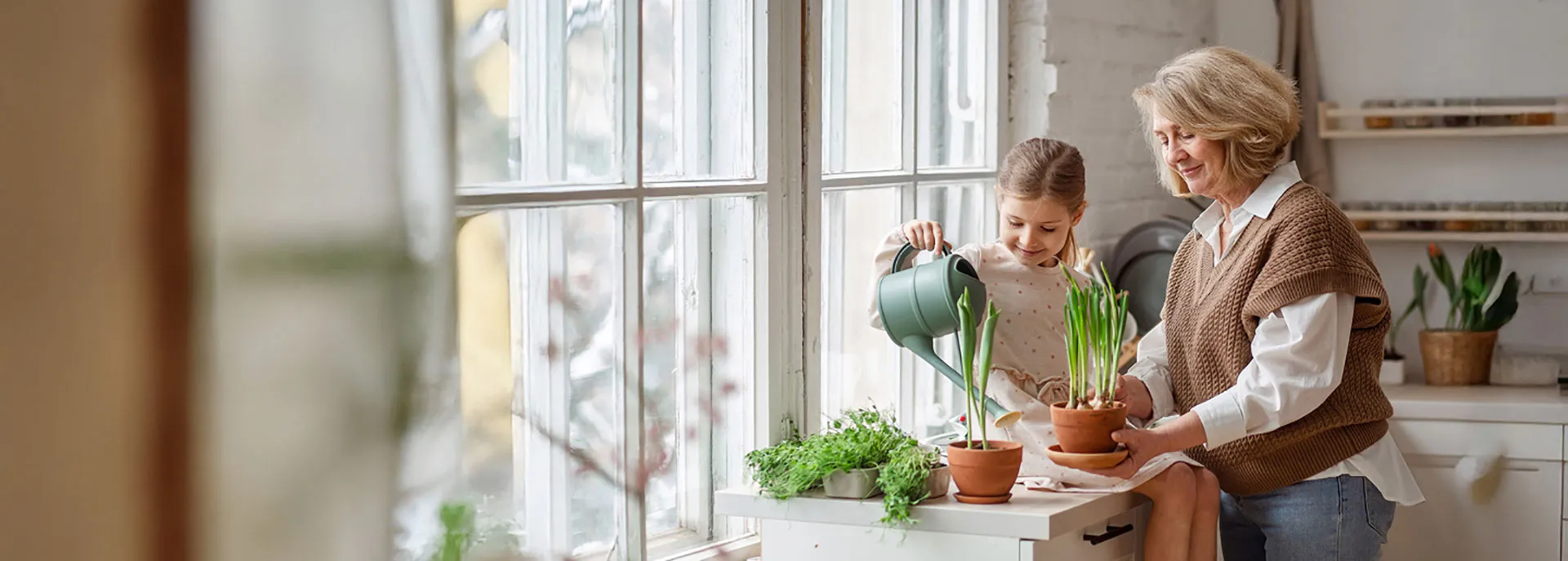 grandma watering plants with granddaughter