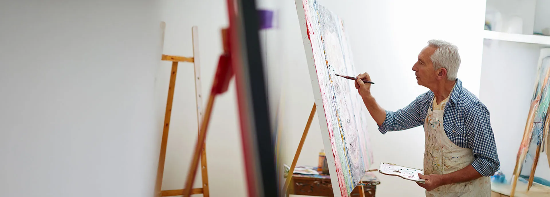 older man painting a canvas
